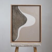 Flow 01 mixed media. artwork in beige, brown and white hues in an oak frame, placed on a stool